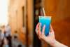 Geheimtipps für Rom: Unbedigt Grattachecca probieren! Das geschabte Eis mit Geschmack – im Bild in Blau, in einem Plastikbecher, der von einer Hand gehalten wird – kühlt an heißen Sommertagen wunderbar!