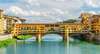 Zu den top Sehenswürdigkeiten in Florenz gehört die Brücke Ponte Vecchio. Auf dem Bild sieht man sie an einem sonnigen Tag. 