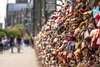 Zu den Sehenswürdigkeiten in Köln gehört die Hohenzollernbrücke. Auf dem Foto sieht man viele bunte Schlösser mit persönlichen Gravuren von Verliebten.