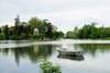 Zu den Sehenswürdigkeiten von Paris gehört der Bois de Vincennes. Im Bild sieht man einen See samt Ruderboot, im Hintergrund das Grün des Parks. 