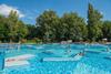 Budapest Thermen: Palatinus -  Am Bild sieht man das Freibad der Therme - mit vielen Luftmatratzen und Menschen. Dahinter sind ein paar Bäume zu sehen.