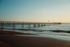Interrail-Packliste: Blick auf den Strand und einen Steg ins Meer bei Rimini. Am Horizont sieht man noch das letzte Rot-Gelb der untergehenden Sonne. 