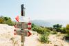 Interrail-Packliste: Im Hintergrund sieht man einen Wanderweg. Im Vordergrund ist ein Wegweiser zu sehen.