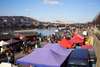 Prag Restaurants: Blick über den Naplavka Bauernmarkt in Prag mit den bunten Dächern der Marktstände. Im Hintergrund die Moldau. 
