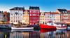 Kopenhagen Sehenswürdigkeiten: Auf dem Bild sieht man bunte Häuser und Schiffe am Hafen von Nyhavn in Kopenhagen.