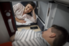 Nachtzug Lifehacks & Tipps: Man sieht zwei Personen die jeweils in ihrer Mini Cabin liegen und sich dabei anschauen aufgrund der verschiebbaren Trenntür, die auf dem Bild offen ist. 