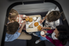 Nachtzug Lifehacks & Tipps: Man sieht aus der Vogelperspektive eine Familie, bestehend aus Mutter, Vater und zwei Kindern, die ihr Frühstück im Nightjet genießt.  