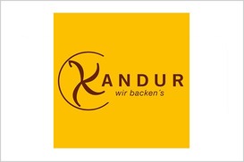 Kandur Logo, gelber Hintergrund mit brauner Schrift