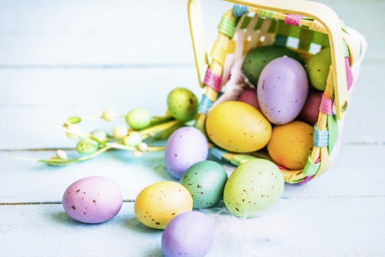 Bunte Ostereier in einem umgefallenen Korb. 