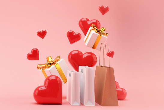 Herzluftballons, Geschenkesackerl und Pakete vor rosa Hintergrund. 