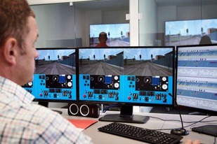 Computerraum, Mann sitzt vor den Monitoren