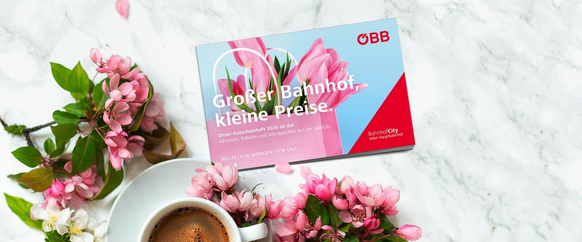 Gutscheinheft und im Hintergrund Blumen und eine Kaffeetasse