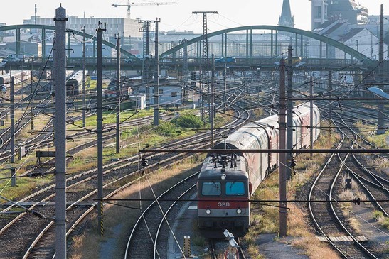 Rail tracks with train leaving a city