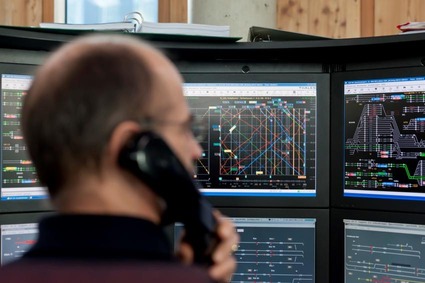 Mitarbeiter der Betriebsleitung beim Telefonieren vor einem Bildschirm