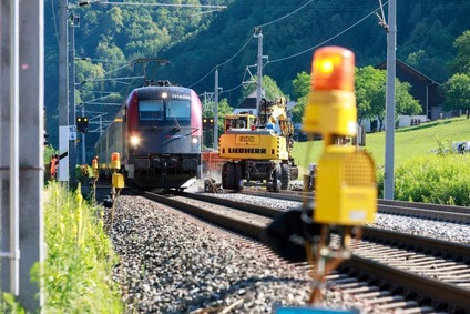 Bahn fährt auf den Schienen mit Berglandschaft