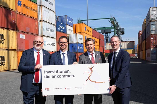 Vier Personen halten eine Infotafel.