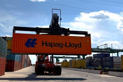 Vehicle lifts a container and stacks it with the others.