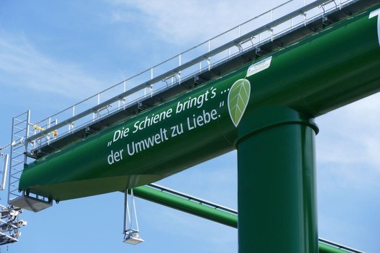 Ein grüner Kran mit der Aufschrift "Die Schiene bringt´s ... der Umwelt zu Liebe."