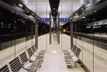 Foto Bahnsteig Feldkirch<br/>Textinsert: Nachtstimmung mit beleuchtetem Bahnsteig am Bahnhof Feldkirch