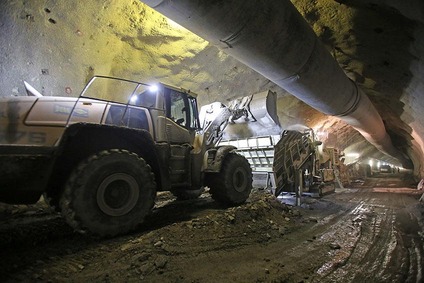 Mehrere Bagger in einer Tunnelröhre bei der Arbeit.