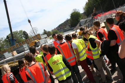 Foto: Besucher der Infowelt Führung<br/>Textinsert: Schulkinder mit Warnwesten bei Führung