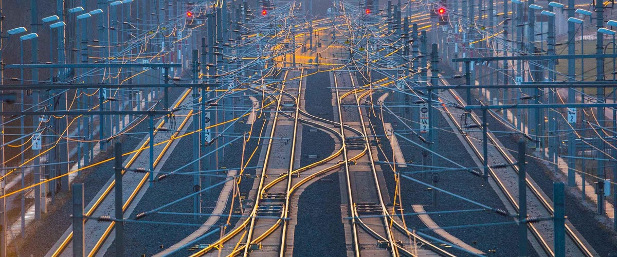 Photo: ÖBB switches and signals<br/>Text insert: Image showing multiple tracks, switches, and four red signals