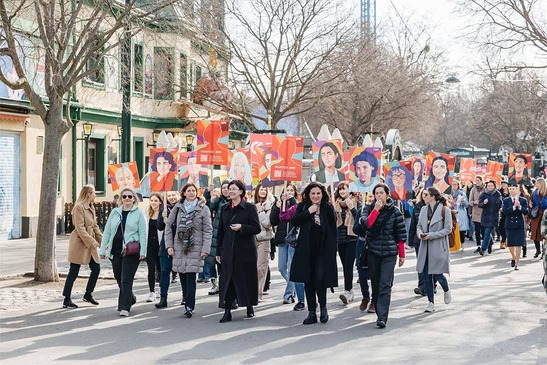 Foto: Powerwalk am Weltfrauentag<br/>Textinsert: Frauen marschieren mit Fahnen