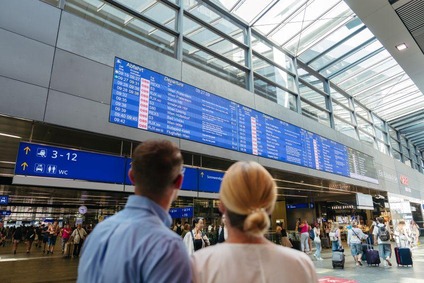 Frau und Mann schauen sich die Abfahrtsmonitore am HBF Wien an