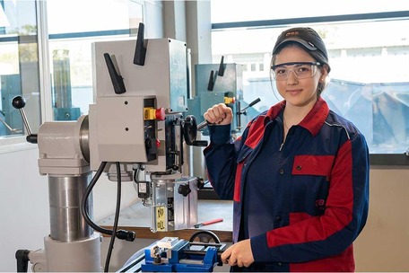 Apprenticeship mechanical engineering technology - apprentice stands by a machine