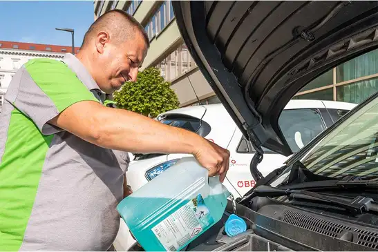 Mitarbeiter der Reinigung serviciert ein CarPool-Fahrzeug