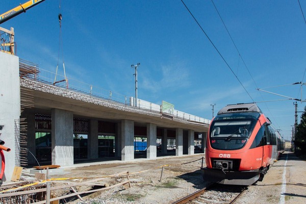 A passenger train passes a construction site.