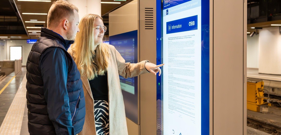 Digitale Infostele - Frau und Mann stehen vor der Infostele