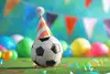Fußball mit Partyhütchen auf Fußballfeld und bunter Wimpelkette im Hintergrund. 