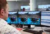 Computerraum mit Mann vor den Bildschirmen