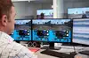 Computerraum, Mann sitzt vor den Monitoren