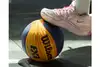 Fuß im Sportschuh steht auf einem Basketball