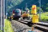 Bahn fährt auf den Schienen mit Berglandschaft