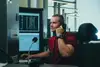 Fahrdienstleiter sitzt auf ihren Arbeitsplatz. Im Hintergrund Computerbildschirme