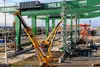 Große grüne Portalkräne werden am INFRA Terminal Wels montiert. Im Vordergrund stehen gelbe Mobilkräne, im Hintergrund sind Container und Gleisanlagen zu sehen.