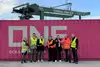 Eight people in front of a container 