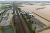 Bild einer Überflutung von Gleisen und eines Bahnhofes von oben 
