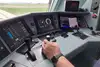 infraDOAS tablet in operation in a driver's cab, and the driver's hand on the control lever