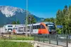 Foto Bahnhof Puchberg am Schneeberg<br/>Textinsert: Haltestelle mit Zug und Bergen im Hintergrund