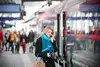 Woman holding her mobile at the station platform.