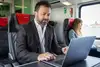 A man on the train working on the computer
