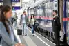 Zwei Personen gehen am Bahnsteig entlang, recht befindet sich der Nighjet.