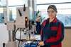 Apprenticeship mechanical engineering technology - apprentice stands by a machine