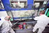 Zwei Mitarbeiter reinigen einen Zug von Graffiti