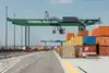 Auf diesem Foto ist ein Portalkran zu sehen. Des Weiteren stehen mehrere Container zum verladen bereit. 