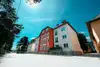 Textinsert: Foto Strasshof, Hauptstraße, Schuhmeierstraße, Heinestraße (Rote Burg) Außenansicht Wohnbau, straßenseitig mit Gärten
